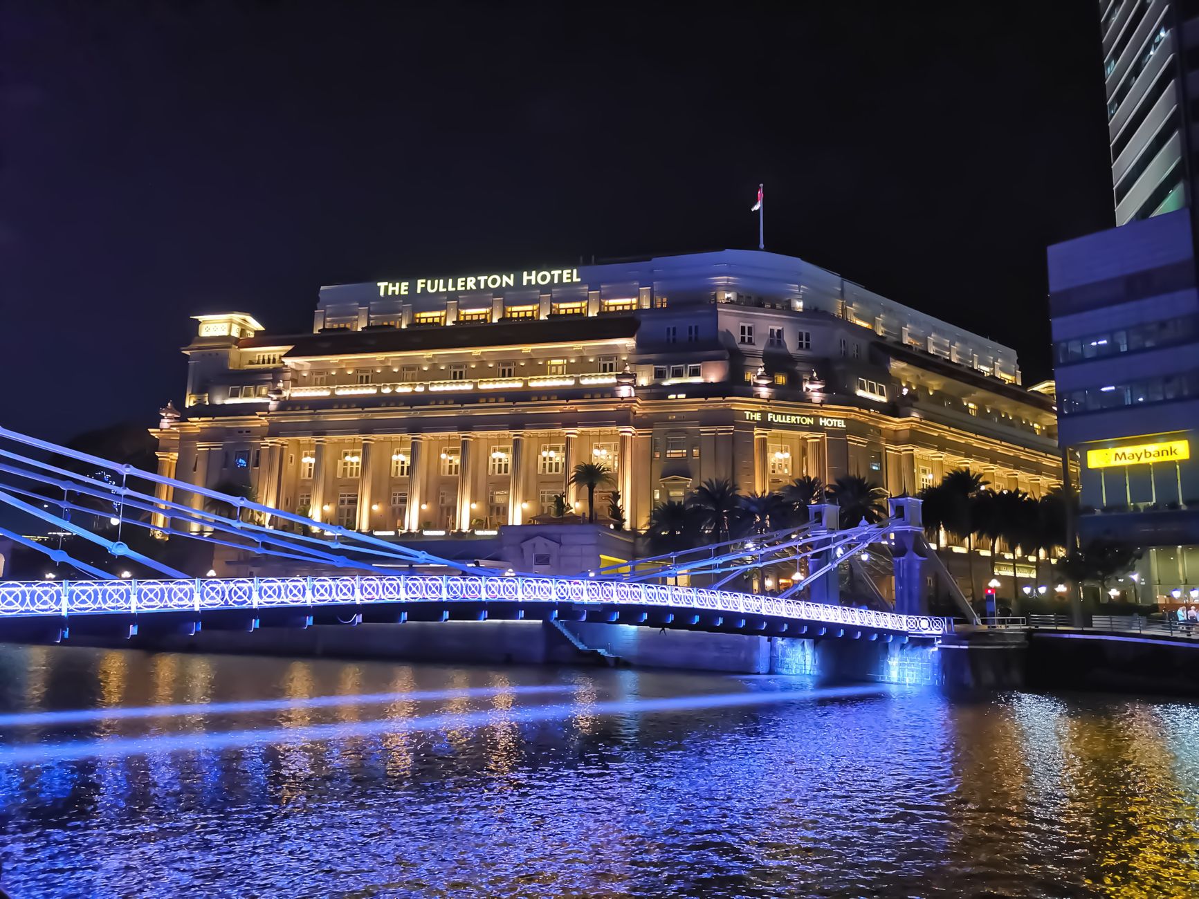 Local SEO in Fullerton, CA near SOCO District | OCWebPros. Illuminated Fullerton Hotel and Cavenagh Bridge reflecting on wate
