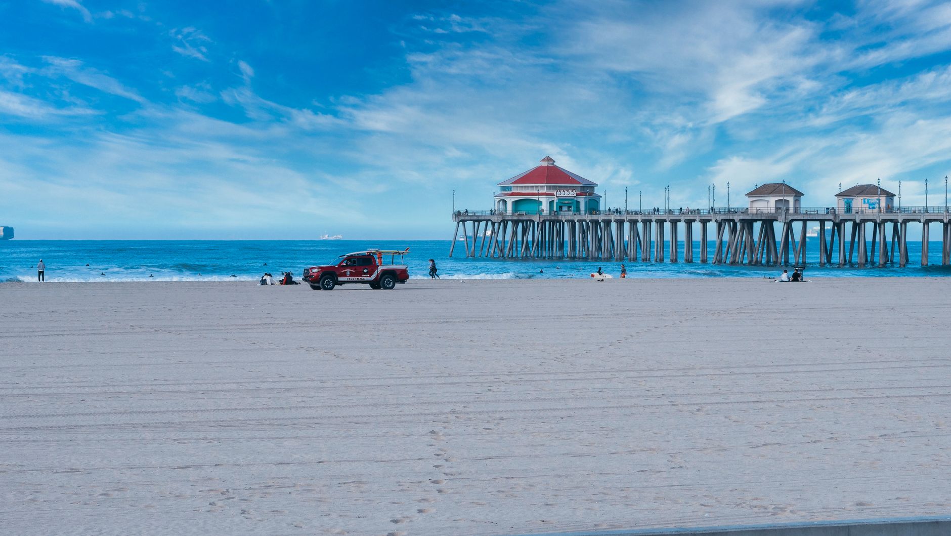 Local SEO in Huntington Beach, CA near Huntington Pier | OCWebPros. Serene view of Huntington Beach Pier with lifeguard vehic
