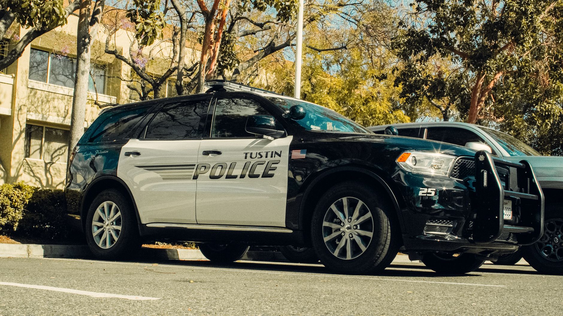 Local SEO in Tustin, CA near Tustin Legacy & The District | OCWebPros. Tustin police car parked in a shaded lot surrounded by