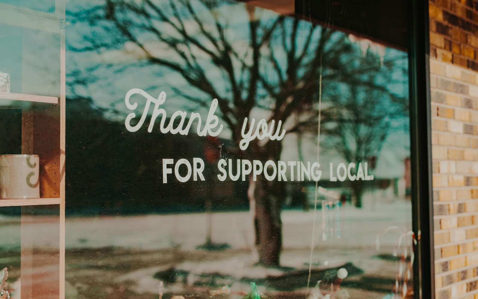 Local business storefront with a support local sign in the window